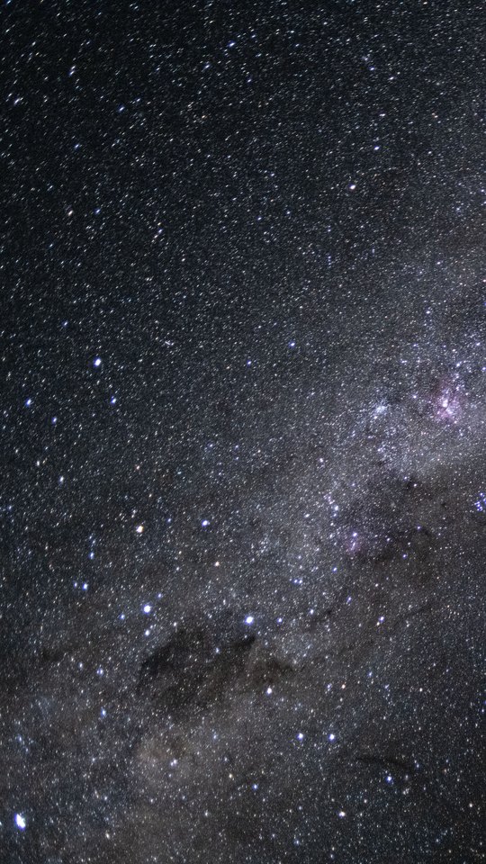 アルテミスII のオリオン宇宙船から撮った天の川。無数の星の帯が斜めに横切り、右上に淡いピンクの星雲が見える。