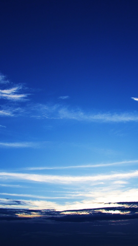 薄い雲の流れる青い空の下に暗い海が横たわっています。
