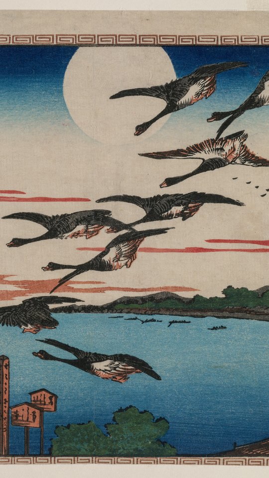 歌川広重の浮世絵。満月の夜空を雁の群れが飛び、下に海辺の家並みと灯り。