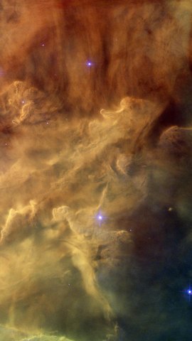 ハッブル宇宙望遠鏡の画像。橙と褐色のガス雲が渦を巻き、間に青い星が光る。