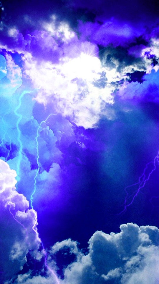 紫と青に染まる嵐雲の中を、稲妻が幾筋も走る劇的な空の写真。