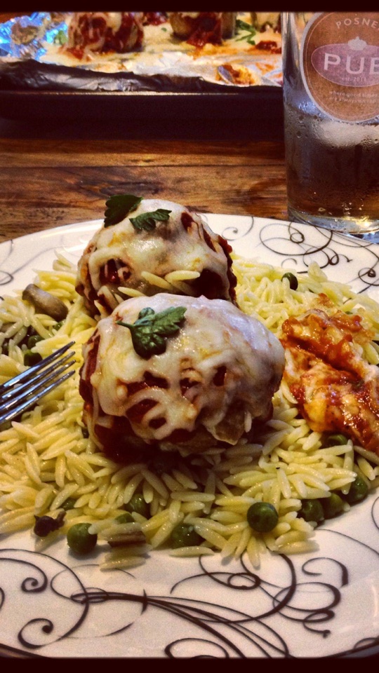 皿に盛られた、チーズをのせたミートボールとパスタの料理をとらえたクローズアップ写真。