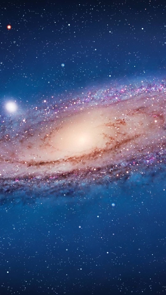 暗い宇宙に渦を巻く銀河が斜めに浮かんでいます。