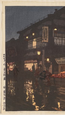 吉田博の木版画。雨上がりの夜の坂道に店の灯りが映り、傘の人が歩く。